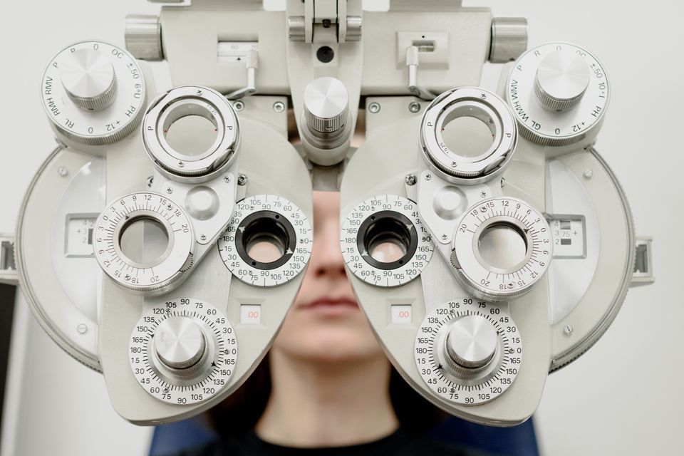 Patient undergoing a refractive vision test with a phoropter for LASIK assessment
