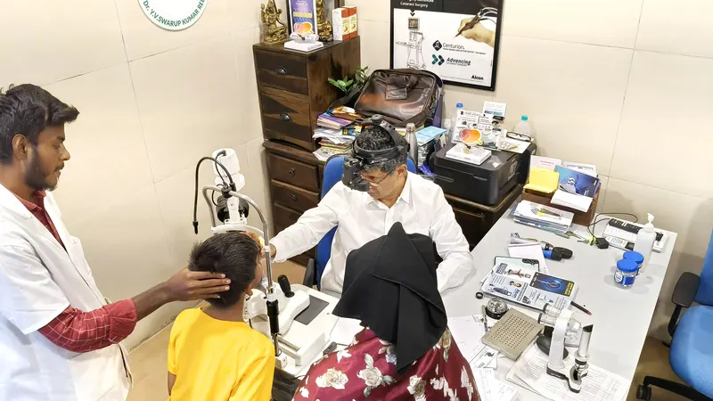 Dr. Swarup examining a young patient during an eye consultation